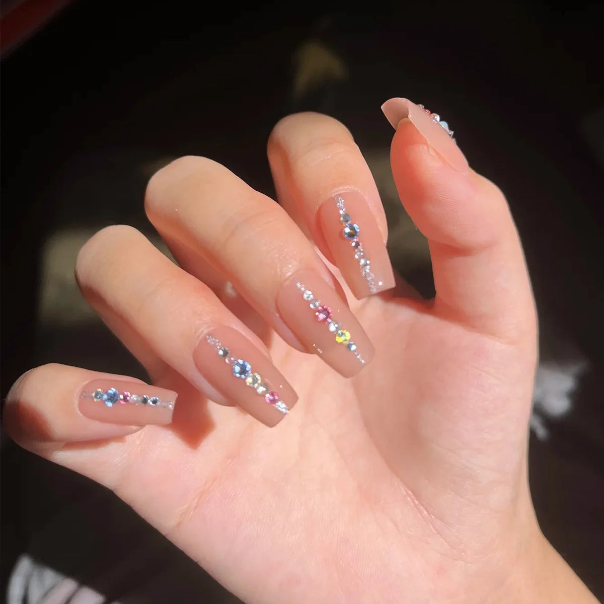 12-pack box of nail accessories: flat-bottom rhinestones, decorative nail embellishments, assorted small components, colorful nail stickers with rhinestones. - Curl and Collar